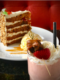 restaurant desserts variety sky high carrot cake, icecream and a fresh fruit milkshake dessert at symposium cafe