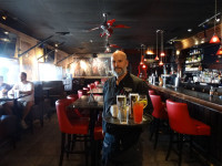 fully licensed bar area showing wait staff serving cocktails at symposium cafe