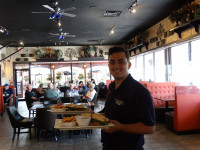 friendly waiter serving food at indoor dining area at symposium cafe